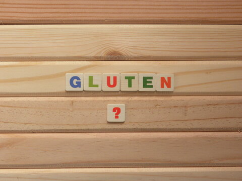 Word Gluten with question mark on wood background