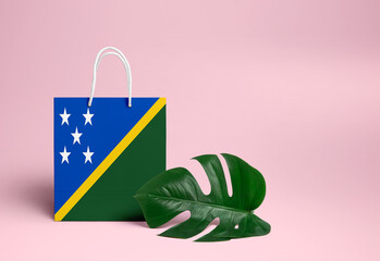 Solomon Islands shopping concept. National cardboard shopping bag with monstera leaf and pink...