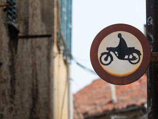 old road sign indicating motorcycle access ban