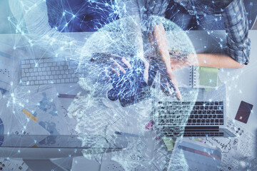Double exposure of man and woman working together and human brain hologram drawing. Brainstorm concept. Computer background. Top View.