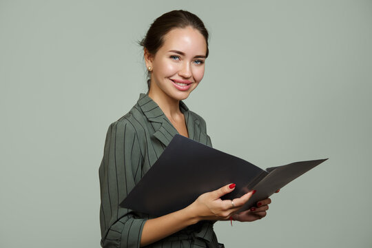 Smiling Woman With A Folder In Her Hands. Portrait On Green Background