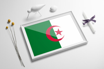 Algeria flag in wooden frame on table. White natural soft concept, national celebration theme.