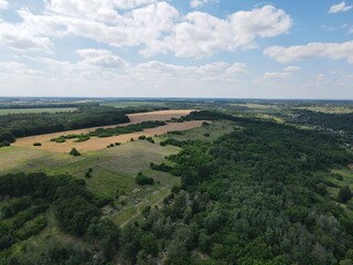 Aerial view of rural summer landscape with fields and forest on a sunny day 
