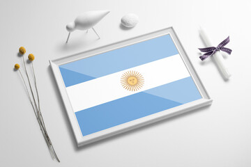 Argentina flag in wooden frame on table. White natural soft concept, national celebration theme.