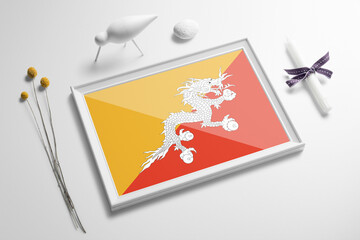 Bhutan flag in wooden frame on table. White natural soft concept, national celebration theme.