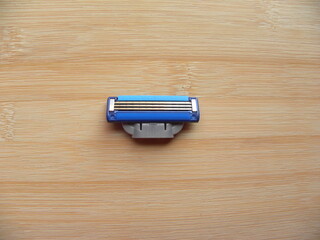 Blue color shaving razor blade cartridge kept on wooden table
