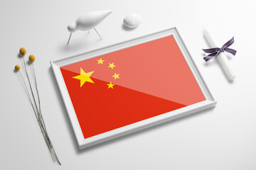 China flag in wooden frame on table. White natural soft concept, national celebration theme.