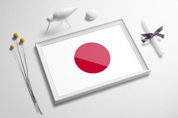 Japan flag in wooden frame on table. White natural soft concept, national celebration theme.