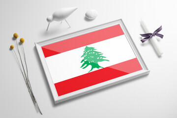 Lebanon flag in wooden frame on table. White natural soft concept, national celebration theme.