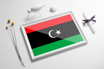 Libya flag in wooden frame on table. White natural soft concept, national celebration theme.