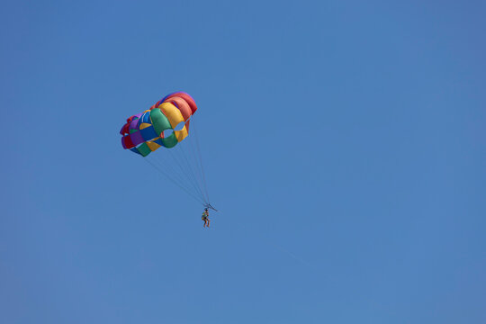 Parasailing, also known as parascending or parakiting, is a recreational kiting activity where a person is towed behind a vehicle (usually a boat) while attached to a specially designed canopy wing
