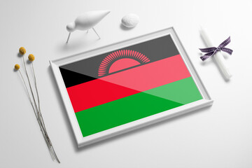 Malawi flag in wooden frame on table. White natural soft concept, national celebration theme.