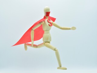 figura de madera con capa y mascarilla corriendo