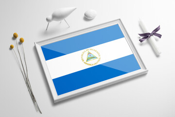 Nicaragua flag in wooden frame on table. White natural soft concept, national celebration theme.