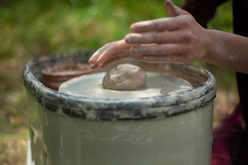 Potter at work. Hands sculpt clay. Creation of dishes.