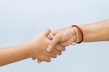 Shaking hands on a grey background - importance of avoiding handshakes during the COVID-19 pandemic