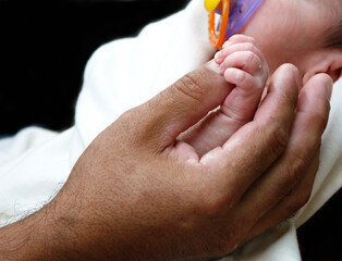 Hand of newborn child and father's hand