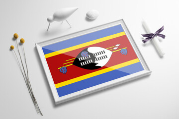 Swaziland flag in wooden frame on table. White natural soft concept, national celebration theme.