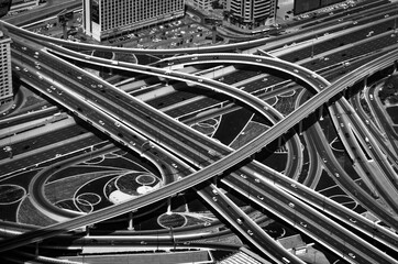 Junction roads viewed from above. Traffic on the highway in Dubai downtown, UAE. Abstract black and...