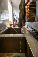 Zwei Becken aus Edelstahl Saftstrahl läuft ins Becken Schlauch steckt im Becken