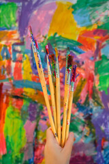 Art brushes on the abstract palette of acrylic paints background