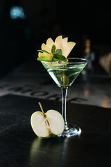 Making cocktails at home like an expert nightclub barman. Fresh and juicy colorful homemade beverages garnished with apple.