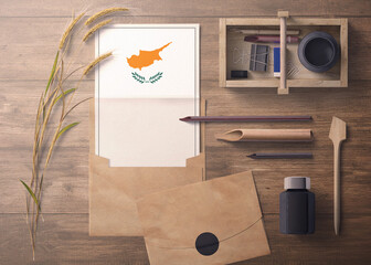 Cyprus invitation, celebration letter concept. Flag with craft paper and envelope. Retro theme with divide, ink, wooden pen objects.