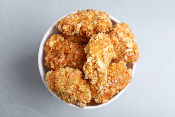 Bucket with yummy nuggets on light background, top view