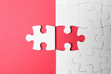 Blank white puzzle with separated piece on red background, flat lay