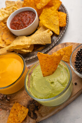 Chips and snacks with avocado and dip sauce, close-up top view