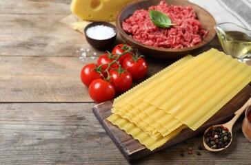 Fresh ingredients for lasagna on wooden table