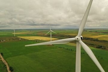 Aerial view of wind turbines in field on cloudy day