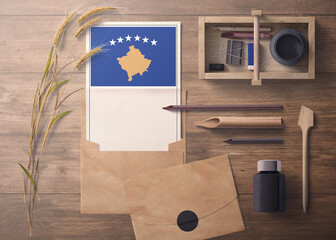 Kosovo invitation, celebration letter concept. Flag with craft paper and envelope. Retro theme with divide, ink, wooden pen objects.