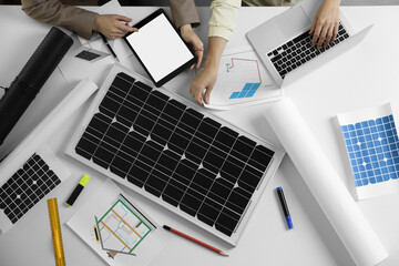 Architects working on house project with solar panels at white table, top view. Alternative energy...