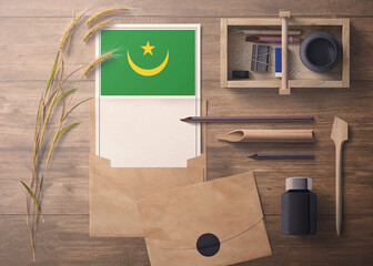 Mauritania invitation, celebration letter concept. Flag with craft paper and envelope. Retro theme with divide, ink, wooden pen objects.