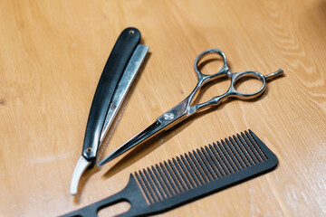 Barber tools. Set of combs of a professional hairdresser. Black combs on a wooden table. Side view.