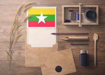 Myanmar invitation, celebration letter concept. Flag with craft paper and envelope. Retro theme with divide, ink, wooden pen objects.