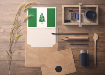Norfolk Island invitation, celebration letter concept. Flag with craft paper and envelope. Retro theme with divide, ink, wooden pen objects.