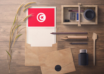 Tunisia invitation, celebration letter concept. Flag with craft paper and envelope. Retro theme with divide, ink, wooden pen objects.