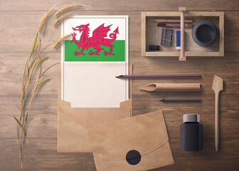 Wales invitation, celebration letter concept. Flag with craft paper and envelope. Retro theme with divide, ink, wooden pen objects.