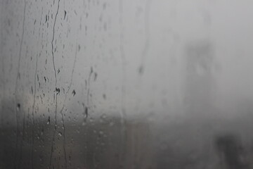 Natural Pattern of raindrops isolated on cloudy background. Rainy day. Raindrops on window glass. Close up shot on droplets of the rain on window glass.