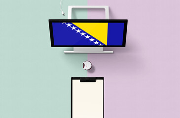 Bosnia Herzegovina national flag on computer screen top view, cupcake and empty note paper for...