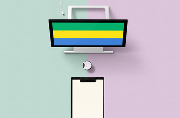 Gabon national flag on computer screen top view, cupcake and empty note paper for planning. Minimal concept with turquoise and purple background.