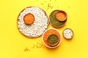 Different raw legumes on color background