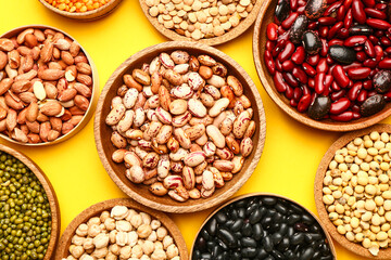 Different raw legumes on color background