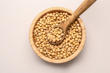 Bowl with raw soy beans on white background