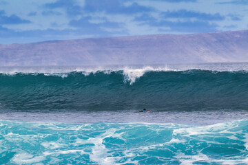 Fototapeta na wymiar Big cresting wave rolling in to shore on Maui.