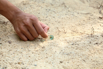 play glass marble on sandy ground