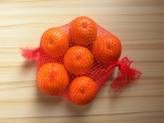 Ripe whole Kinnow mandarin hybrid Orange fruits in net bag © Maneesh