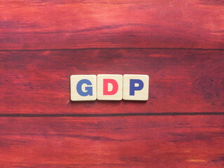 Abbreviation GDP (Gross Domestic Product) on wood background
